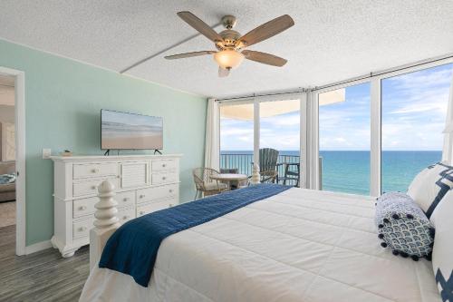een slaapkamer met een bed, een plafondventilator en de oceaan bij The Shores Club 1105 in Daytona Beach