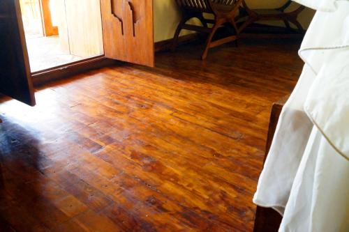a room with a wooden floor and a wooden door at Lafyu Bali in Singaraja
