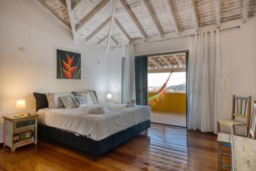 Búzios - Villa exceptionnelle في بوزيوس: غرفة نوم بها سرير ونافذة كبيرة