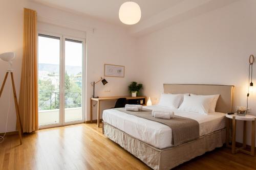 a bedroom with a large bed and a large window at Nakos Homes Luxury Apartment-Acropolis Area in Athens