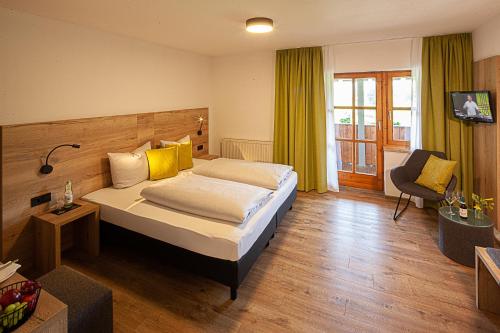 a hotel room with a bed and a chair at Berger's Bergsicht by edita in Scheidegg