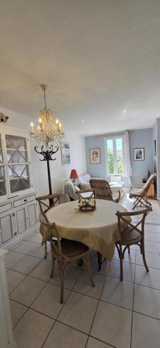 - un salon avec une table, des chaises et un lustre dans l'établissement 