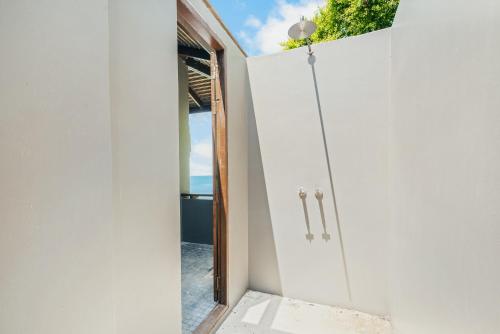 a door leading into a white room with a window at The Kala in Amphoe Koh Samui