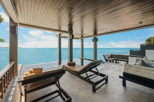 a patio with a view of the ocean at The Kala in Amphoe Koh Samui