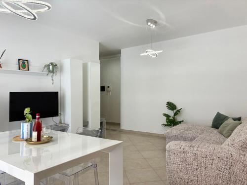 a white living room with a table and a couch at Holihome Mondo Serena in Tortoreto Lido