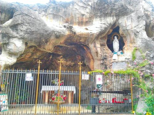 a church with a statue in a rock formation at Luna del Belvedere in Asti