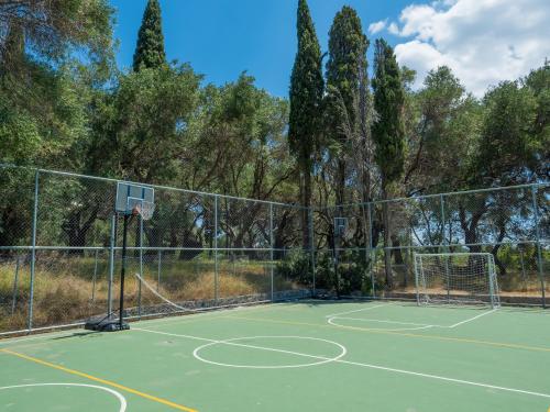 a tennis court with a net and a basketball hoop at Paleo ArtNouveau Hotel - Adults Only in Paleokastritsa