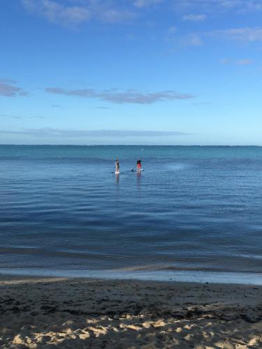 two people standing in the water at the beach at Poétitude in Bourail