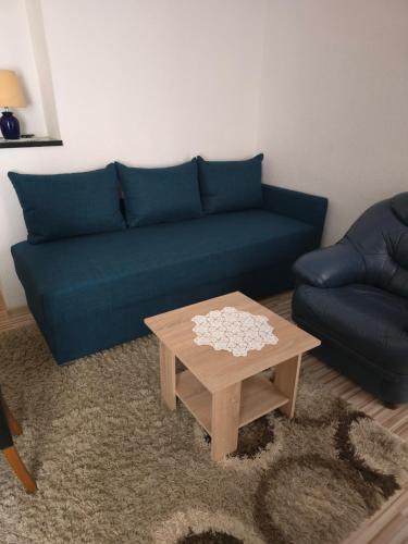 a living room with a blue couch and a coffee table at Guest House Nana in Mostar