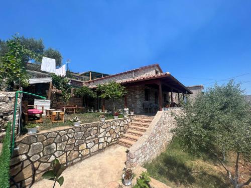 a house with a stone fence and a stone wall at Vokopola Villa in Sarandë
