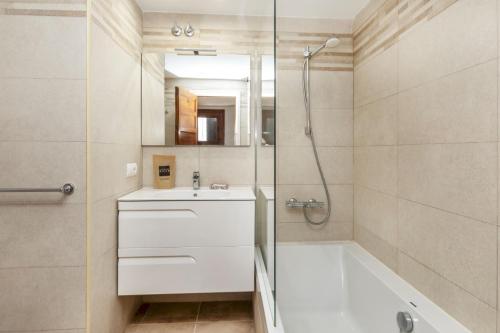 Un baño con bañera, lavabo y ducha. en Cala Nostra- Roca Rosa, en Tamariu