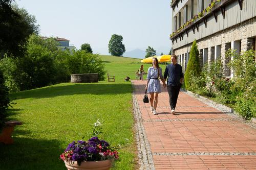 a man and woman walking down a brick sidewalk at Berger's Bergsicht by edita in Scheidegg