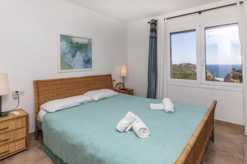 Un dormitorio con una cama con toallas. en Cala Nostra- Roca Rosa, en Tamariu