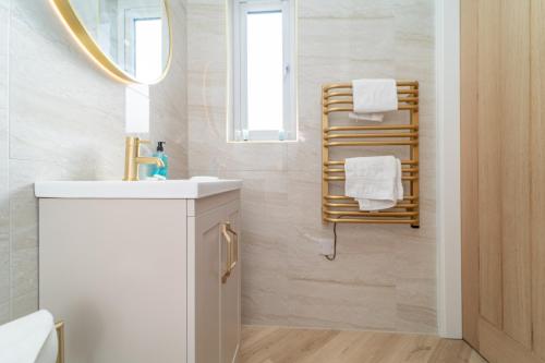 a bathroom with a sink and a mirror and towels at Bankton Rooms & Lodges in Livingston