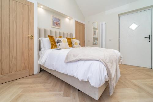a bedroom with a large white bed with pillows at Bankton Rooms & Lodges in Livingston