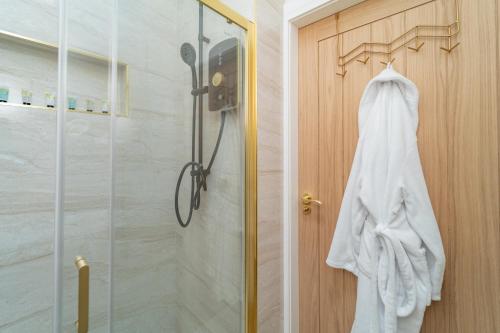 a robe hanging on a door in a bathroom at Bankton Rooms & Lodges in Livingston