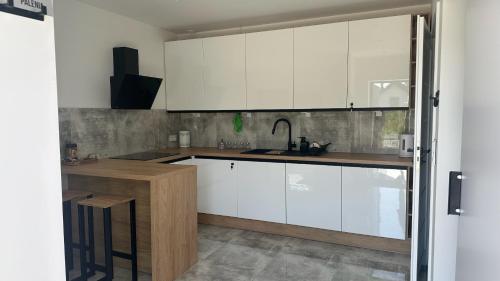 a kitchen with white cabinets and a sink at Nowa Olza - domek na wynajem in Olza