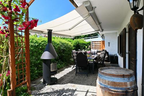 an outdoor patio with a table and a white pergola at Chiemsee-Ferienhaus Schlegel in Breitbrunn