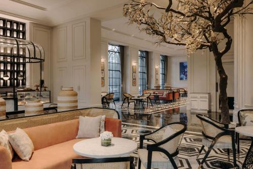 a lobby with a couch and tables and a piano at Fairmont Mumbai in Mumbai