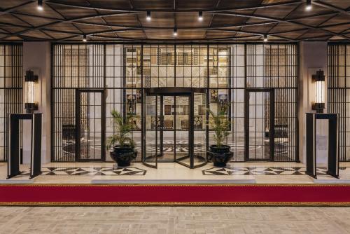a lobby with potted plants and stained glass windows at Fairmont Mumbai in Mumbai