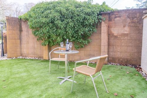 a table and two chairs sitting on a lawn at Bankton Rooms & Lodges in Livingston