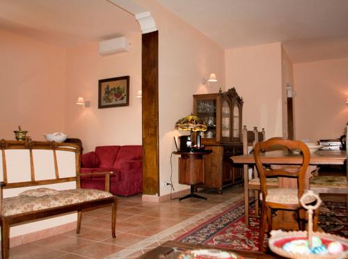 Relais La Mimosa في Pontinia: غرفة معيشة مع طاولة وأريكة حمراء