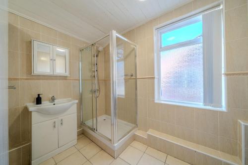 Sleeps 7- Spacious 3 Bed House w Free Parking في ليفربول: حمام مع دش ومغسلة ونافذة