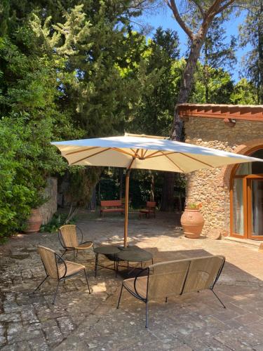 a patio with a table and chairs and an umbrella at Berenice in Chianti - Authentic Tuscan Country House in Bagno a Ripoli