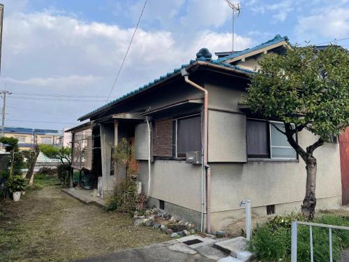 a house with a tree in front of it at like living in a traditional Japanese house, Accessible! one group per day! in Hirakata