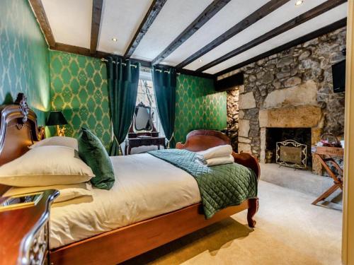 a bedroom with a bed and a stone fireplace at The Tormaukin in Glendevon