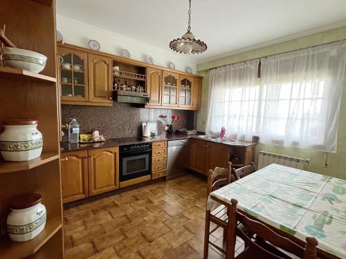 a kitchen with wooden cabinets and a table with a tableablish at Casa María in Santa Eulalia