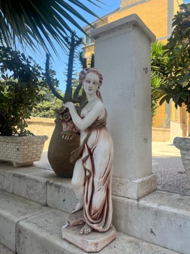 a statue of a woman sitting on some steps at Casa Veranda sul mare in Gela