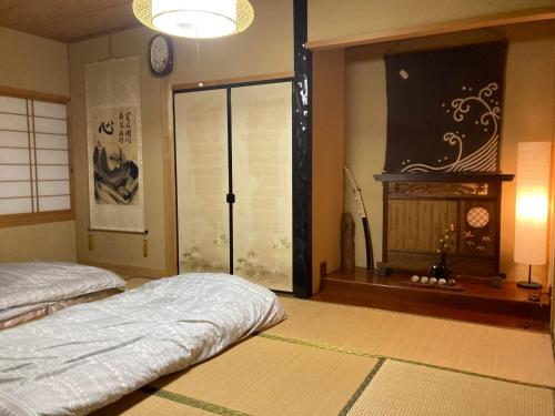 a bedroom with two beds and a window and a clock at Monet House モネハウス in Shimo-horado