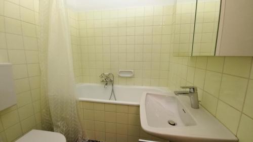 a bathroom with a tub and a sink and a toilet at VERONIKA Haus KMB Seeappartement am Ossiacher See mit direktem Seezugang und Hallenbad in Tschöran