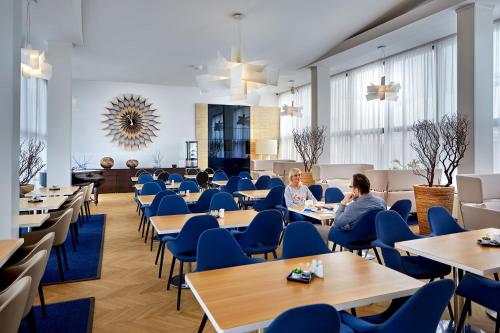 a dining room with blue chairs and tables at Vilas & Wellness Resort Orlík in KozÃ¡rovice