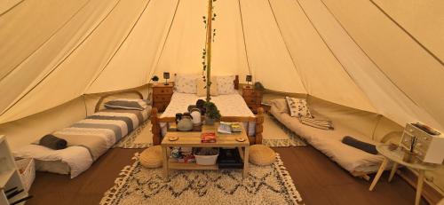 a tent with couches and a table in it at Sŵn Y Môr bell tent