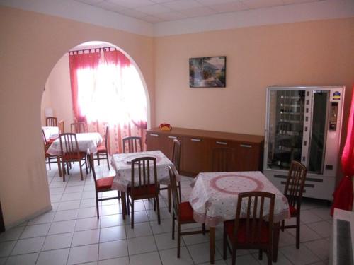 a dining room with two tables and chairs and a kitchen at Hotel Polo in San Felice sul Panaro