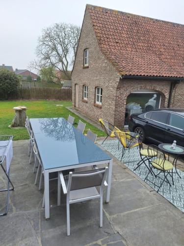 a patio with a table and chairs and a car at Rustige privékamer sandra voor 2- 3 personen in Deinze