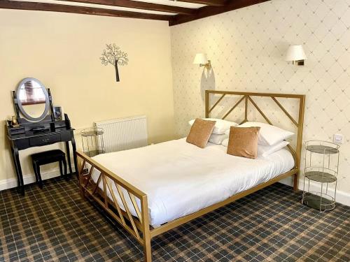 a bedroom with a bed and a mirror and a television at The Tormaukin in Glendevon