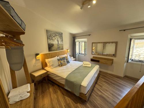 a bedroom with a large bed and a mirror at Nina's House by CorfuEscapes in Doukádes