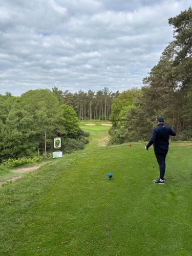 a man is playing golf in a field at Cottage 4 chambres avec cheminée in Épégard