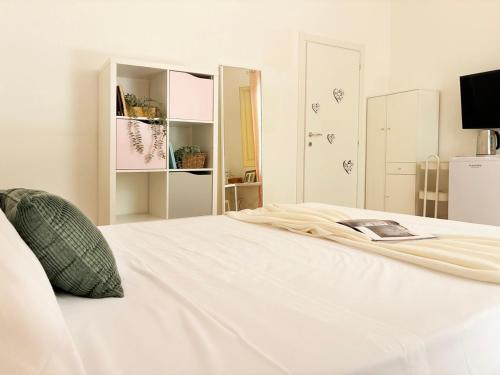 a white bed with a book on top of it at Holihome Room Eight in Tortoreto Lido