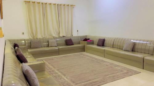 a living room with a large couch with pillows at شقة رهف الجنوب in Salalah