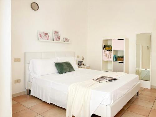 a white bedroom with a white bed and a clock at Holihome Room Eight in Tortoreto Lido