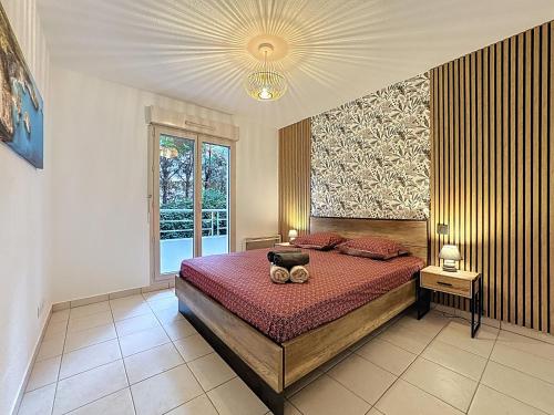Un dormitorio con una cama y una ventana grande. en Cosy nid, terrasse & 2 parkings, en Antibes