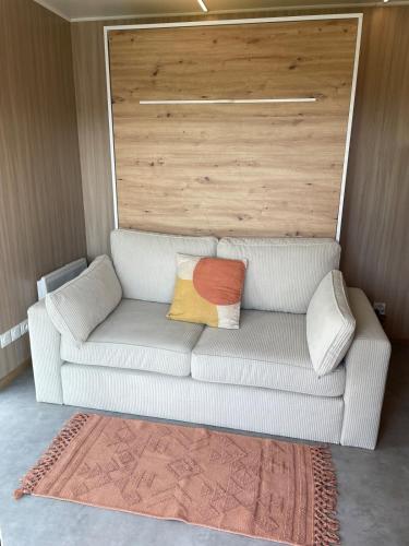 a white couch with two colorful pillows on it at Cocon avec spa et vue imprenable in Chindrieux