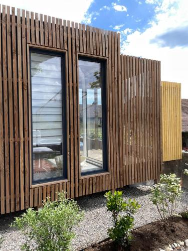a wooden building with two windows on it at Cocon avec spa et vue imprenable in Chindrieux