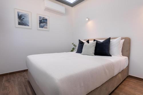 a bedroom with a large white bed with pillows at Palaiomylos Forest Residence 