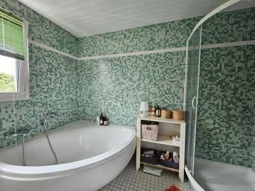 une salle de bain avec baignoire et douche en verre dans l'établissement La Govelle, au Pouliguen