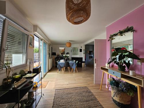 un salon aux murs roses et une salle à manger dans l'établissement La Govelle, au Pouliguen